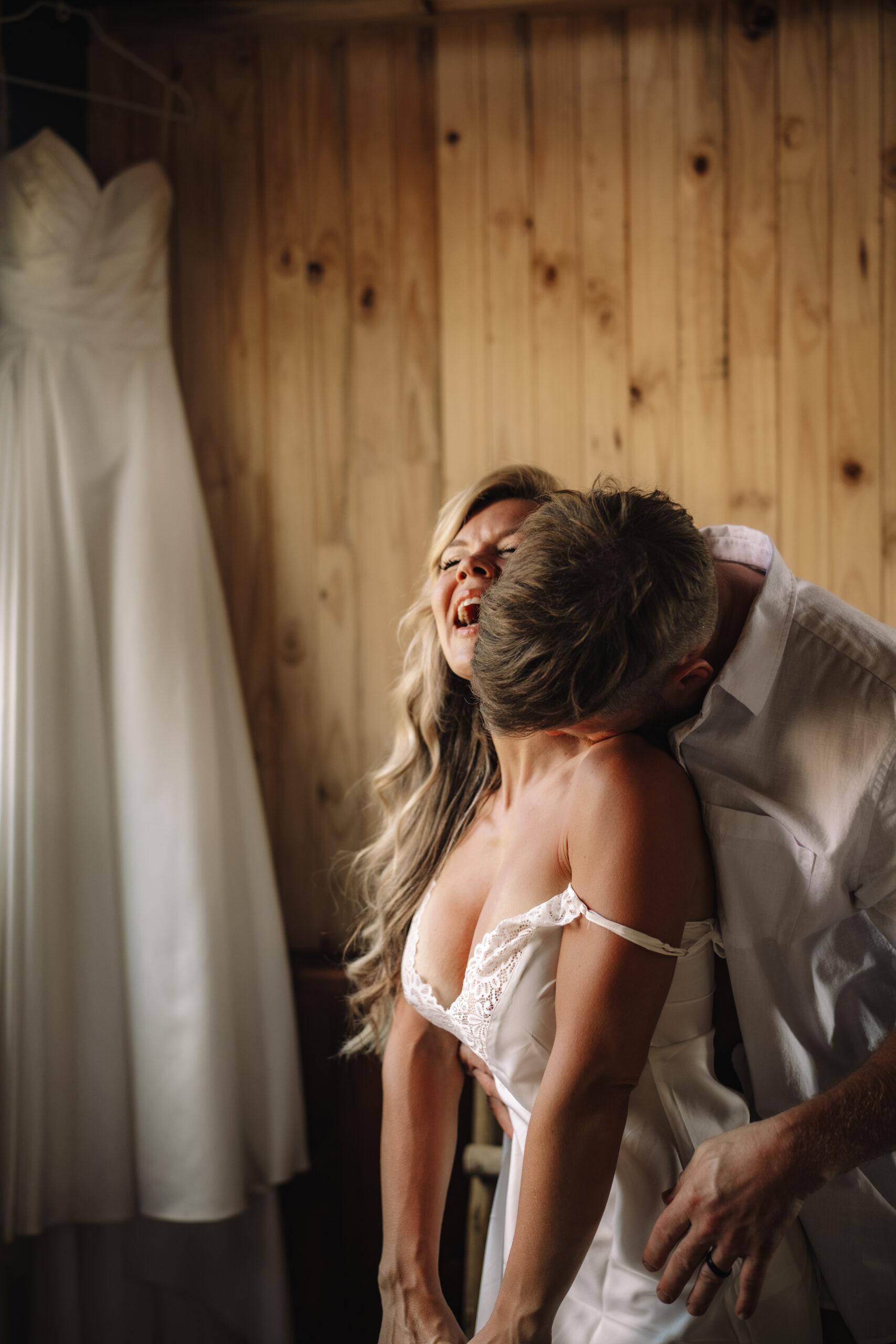 Intimate moment of groom embracing bride while she laughs during getting ready at a safari lodge