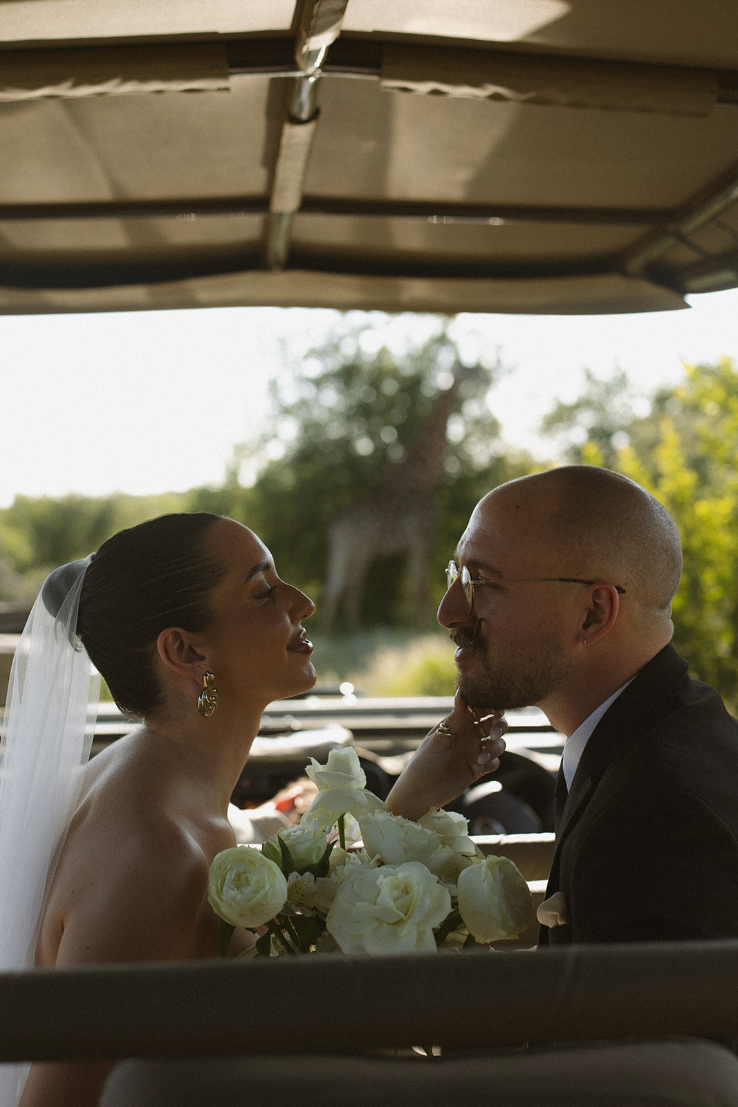 Bride and groom sharing a quiet moment in safari vehicle after they elope in South Africa
