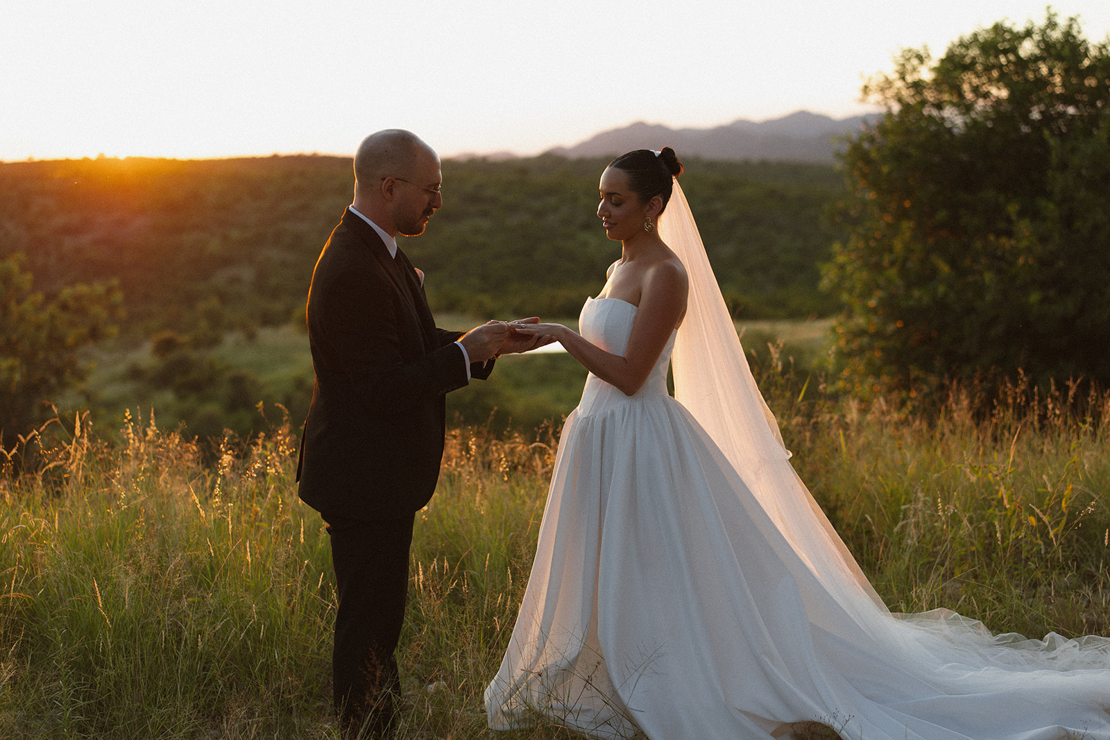 Groom placing wedding ring on bride’s finger at sunset as they elope in South Africa
