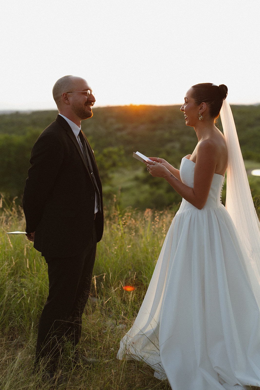 Bride reading vows to groom at sunset during their intimate safari ceremony
