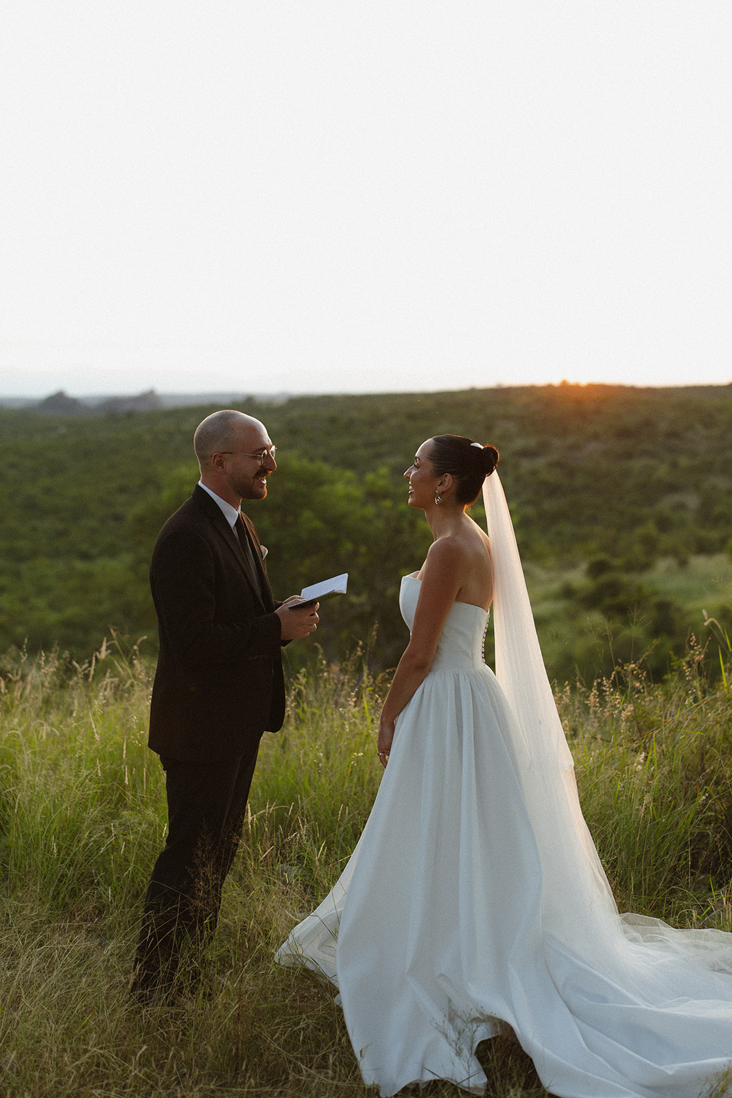 Groom reading vows to bride during golden hour elopement in the South African bush
