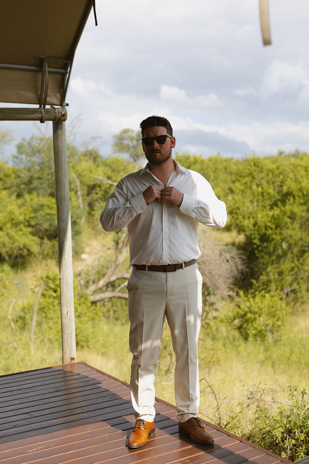 Groom getting ready on safari lodge deck before intimate elope in South Africa
