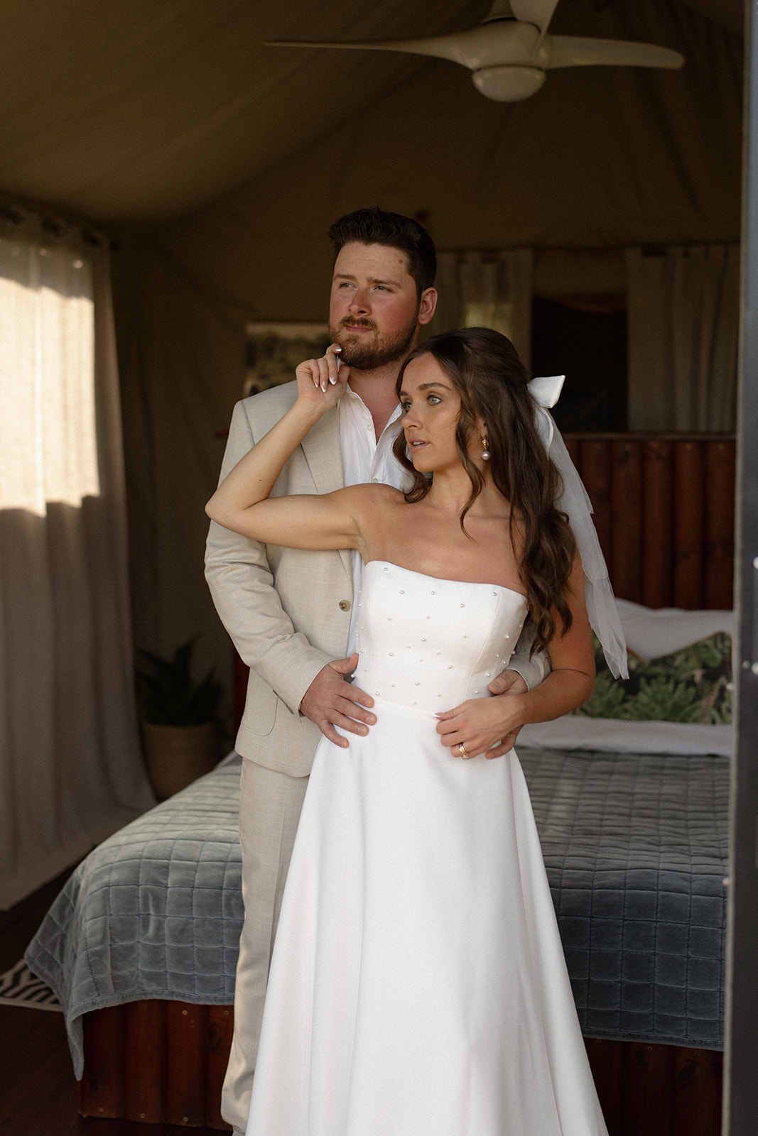 Newlywed couple embracing in safari tent doorway after their intimate elopement
