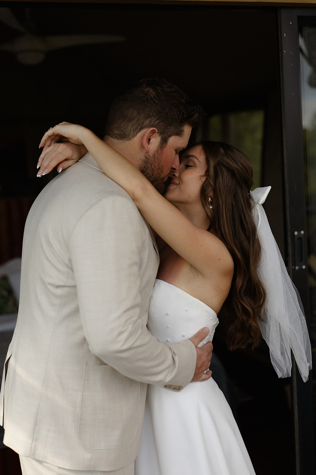 Bride and groom sharing a kiss in safari lodge doorway after their intimate elope in South Africa