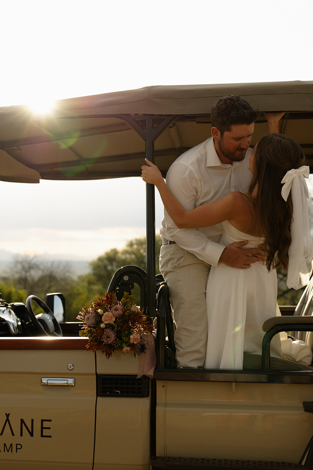 Couple embracing in safari vehicle at sunset after choosing to elope in South Africa
