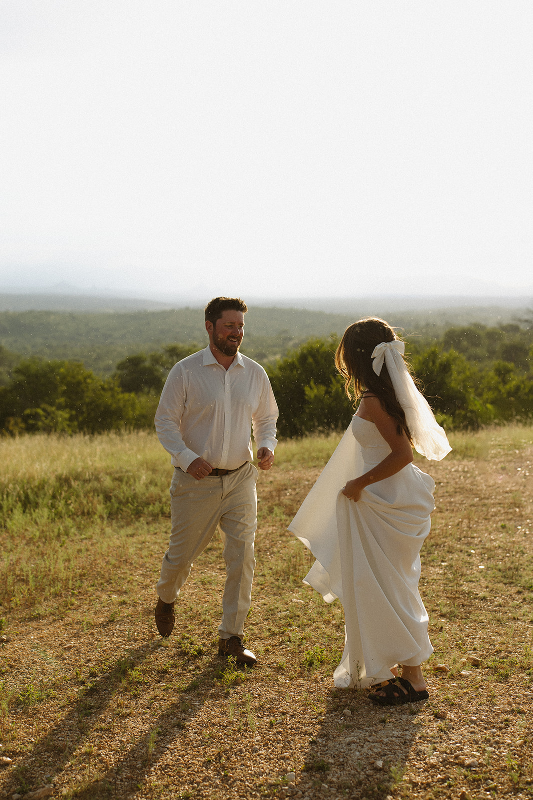 Bride and groom laughing together on hilltop during adventurous elope in South Africa
