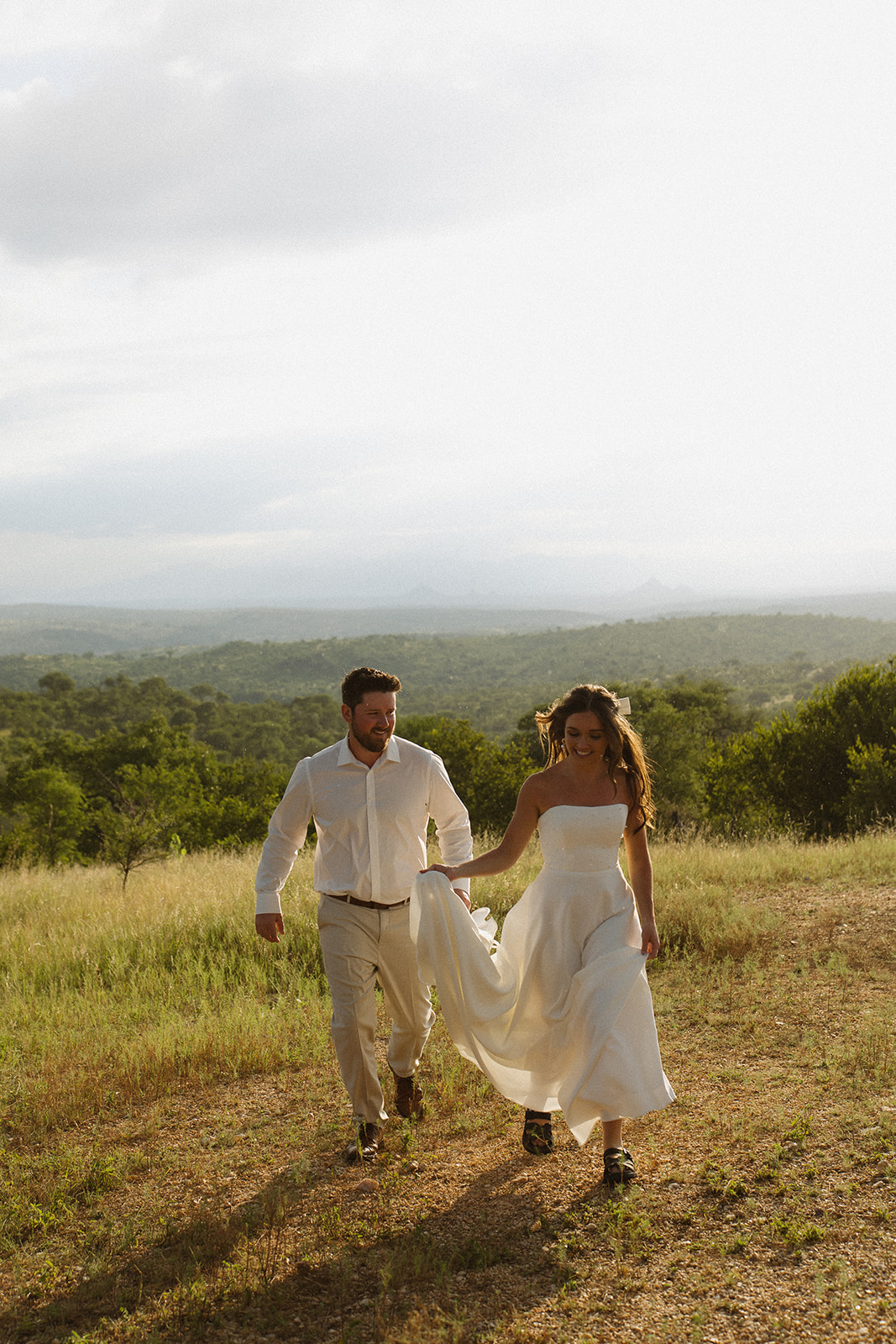 Newlywed couple walking through the African bushveld after their safari elopement
