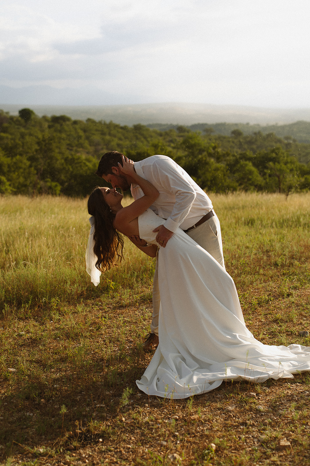 Bride dipped by groom for a sunset kiss in open grasslands after they elope in South Africa
