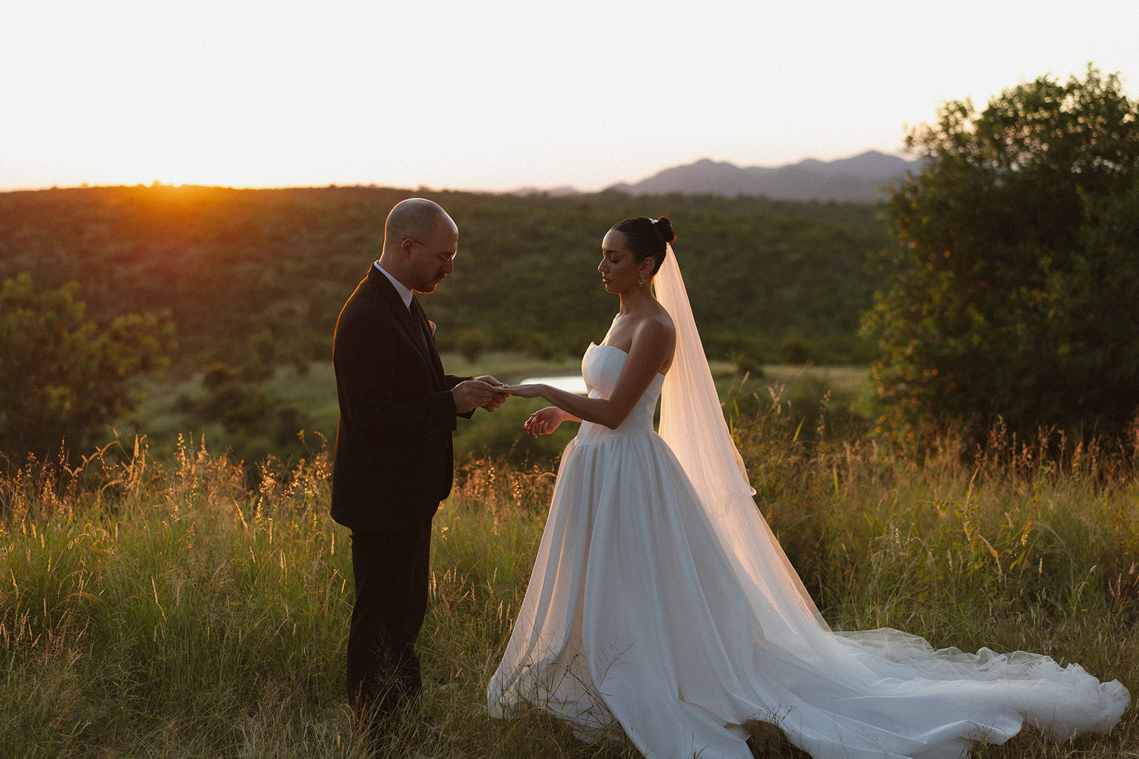 Bride and groom exchanging vows at sunset overlooking the African bush during an intimate Africa weddings ceremony.
