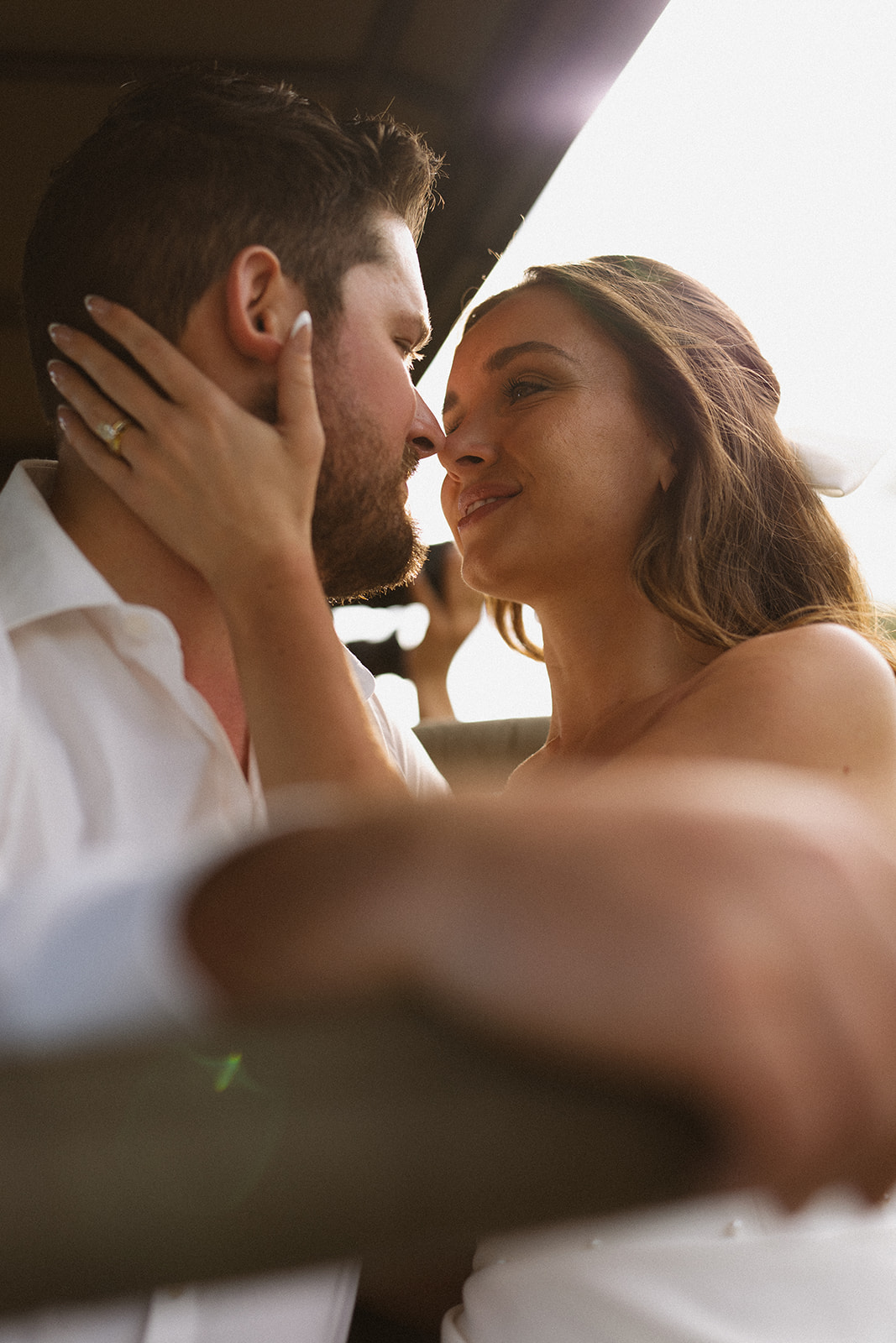Close-up of bride and groom sharing an intimate look with soft golden light during their wedding day
