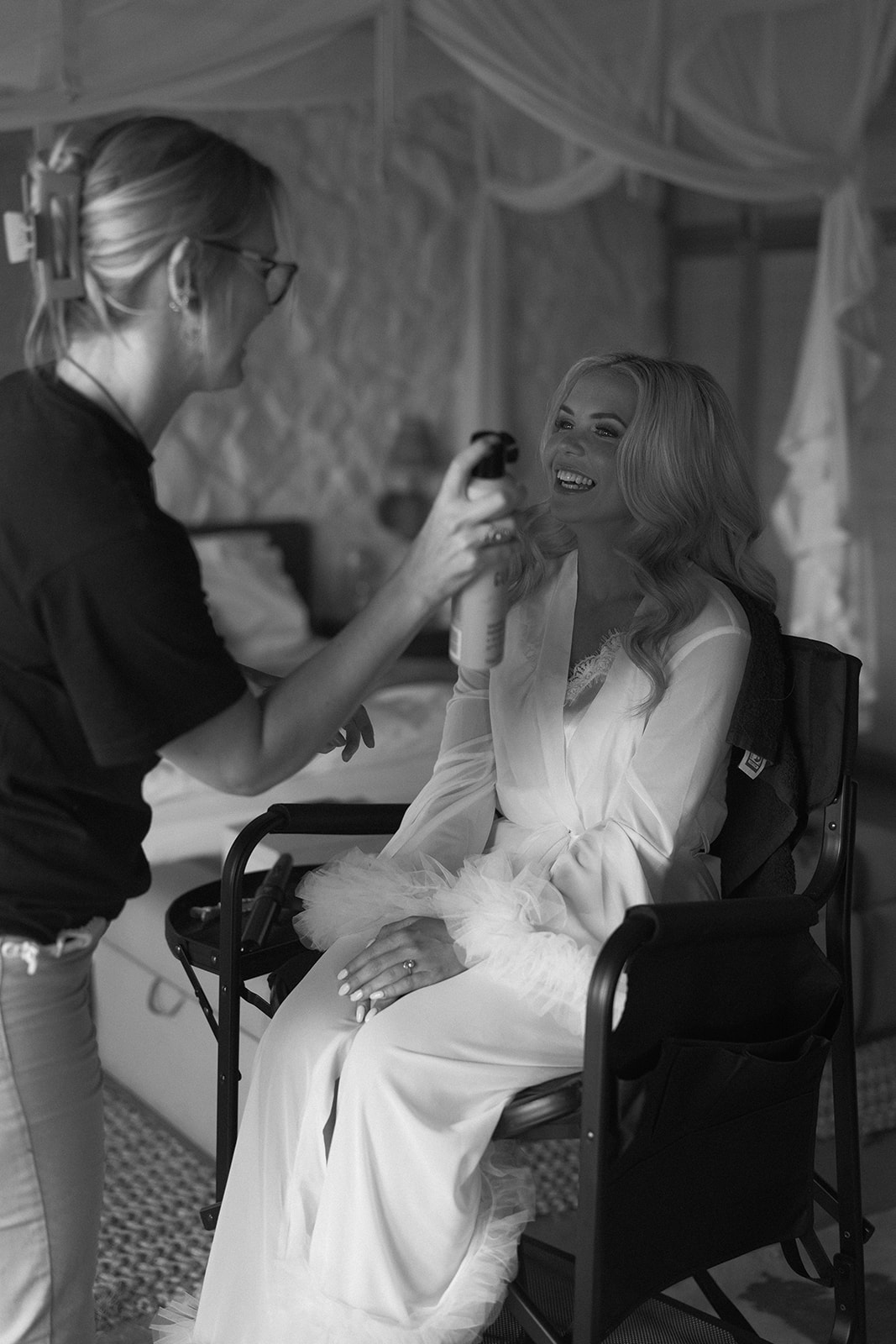 Bride smiling while getting ready with hair and makeup artist before her safari wedding in South Africa