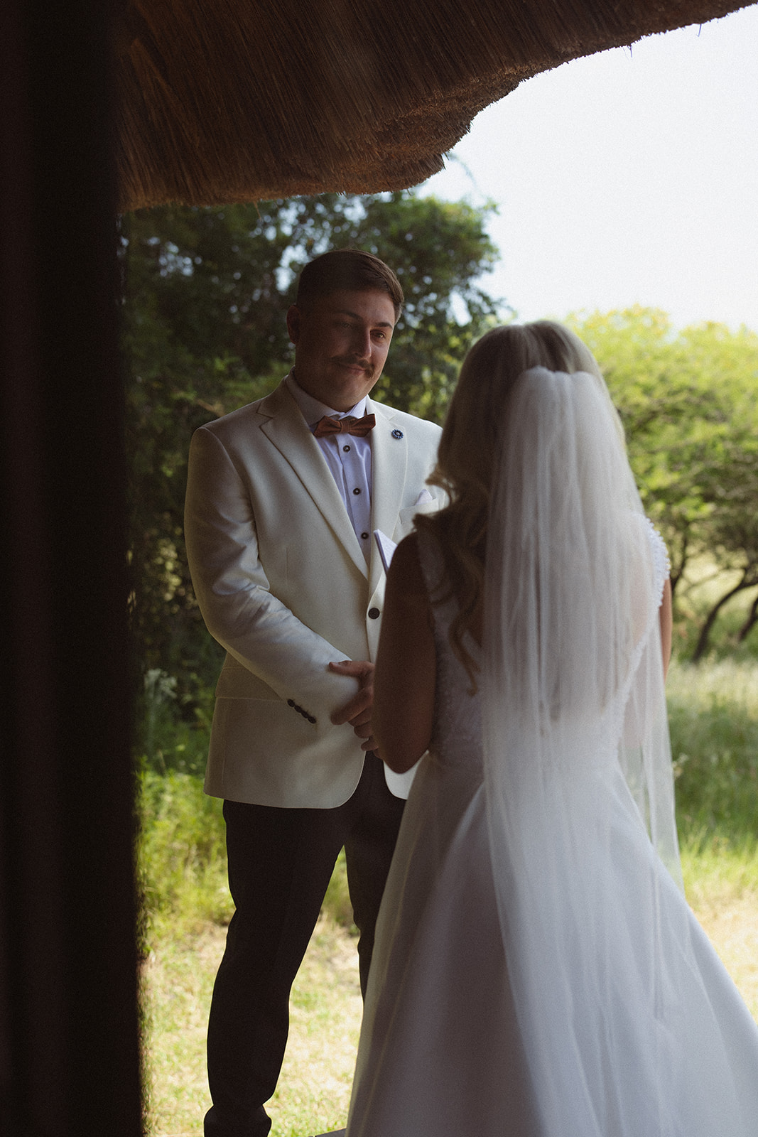 Groom smiling during a first look with bride outside a safari lodge in South Africa