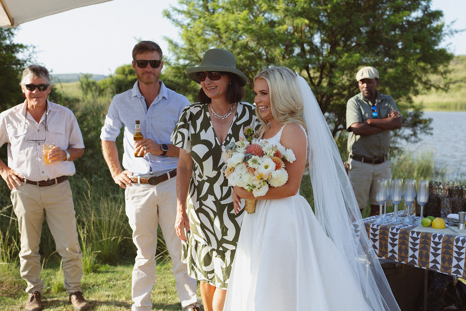 Bride laughing with guests near champagne table after ceremony in South Africa
