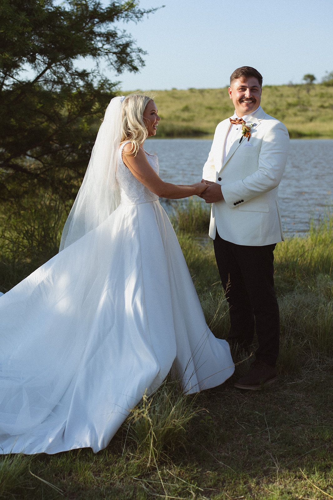 Bride and groom holding hands near water during a safari wedding in South Africa