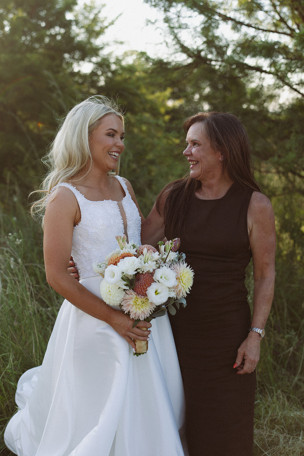 Bride and her mother sharing a joyful moment together before ceremony