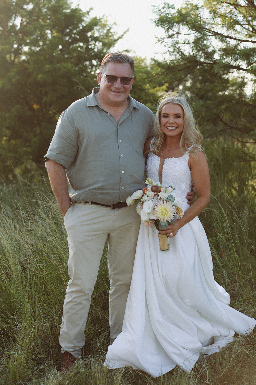 Bride posing with her father in soft evening light during a safari wedding in South Africa