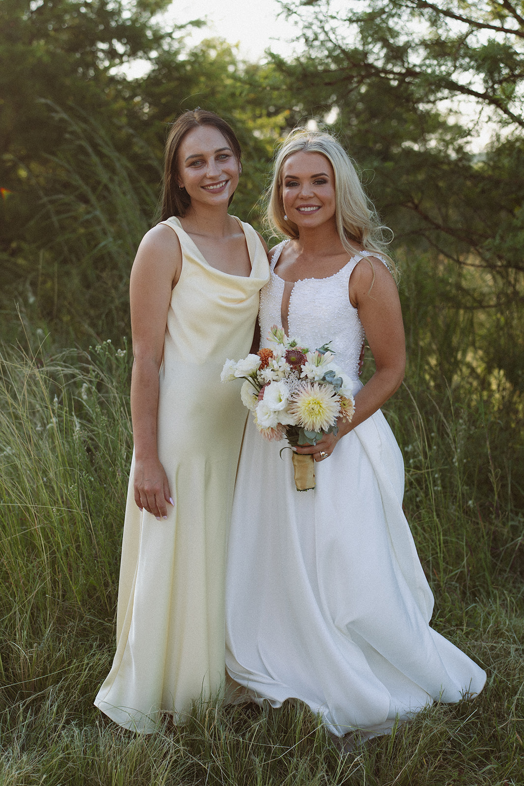 Bride posing with bridesmaid in natural setting during a safari wedding in South Africa