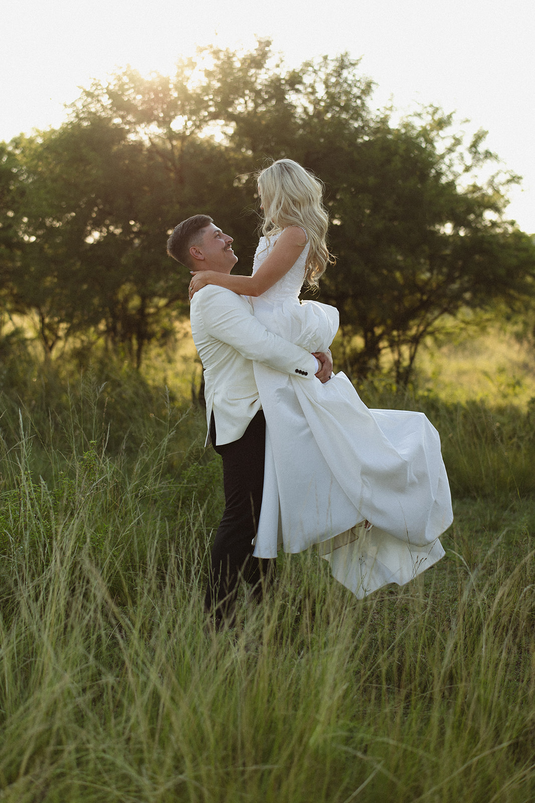 Bride smiling in safari vehicle during golden hour after wedding ceremony in South Africa