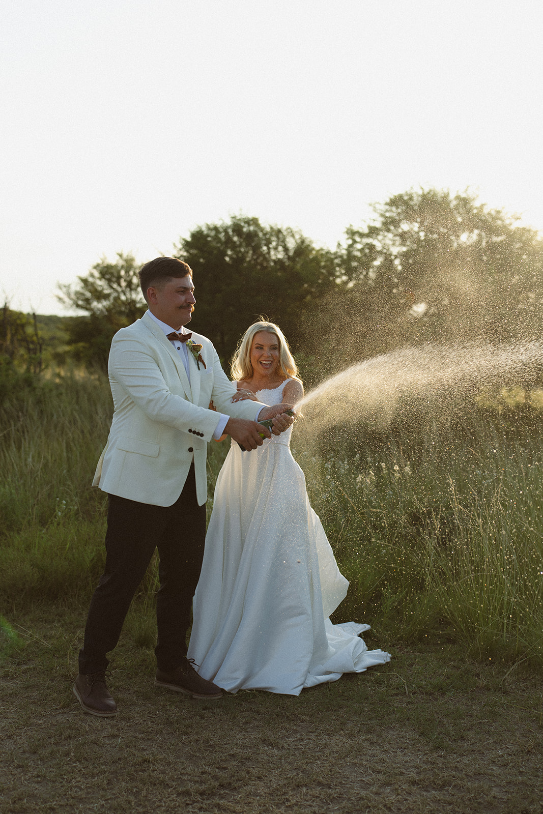 Bride and groom popping champagne in open landscape during a safari wedding in South Africa