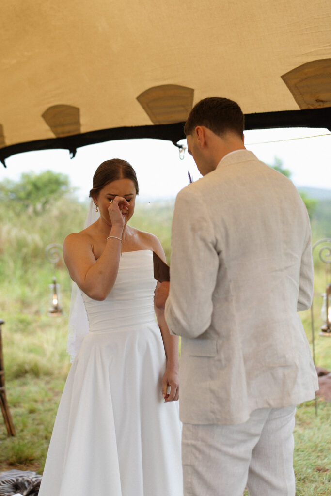 Larissa wiping away tears while exchanging emotional vows with Shay during their Nambiti Hills safari wedding