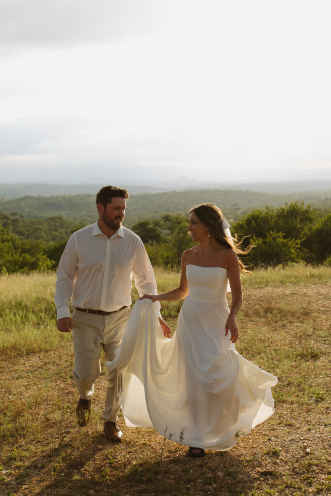 Couple walking together through the South African bush during their five-year safari vow renewal
