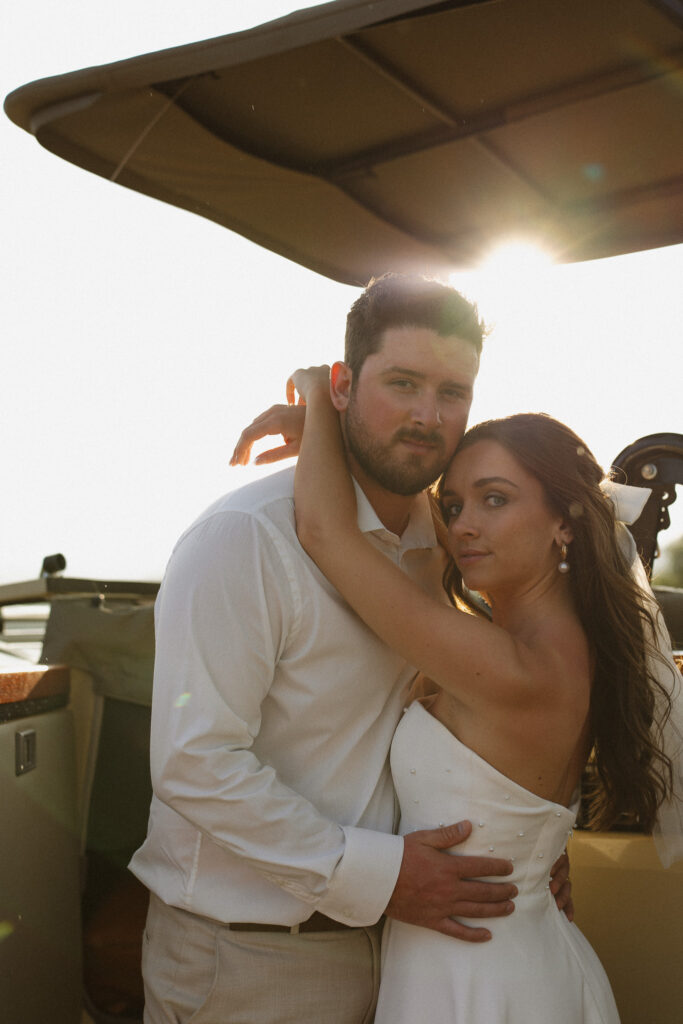 Jody and Alex posing beside an open safari vehicle during their South Africa vow renewal
